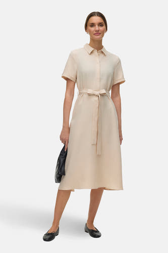 Robe écru à manches courtes de Vero Moda, avec une ceinture à nouer et des chaussures plates noires.