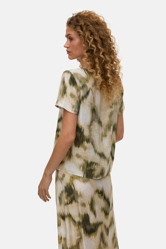 Multicolor blouse met korte mouwen van VERO MODA® met abstracte groen-beige print, gedragen met bijpassende rok, zij-achterkant.