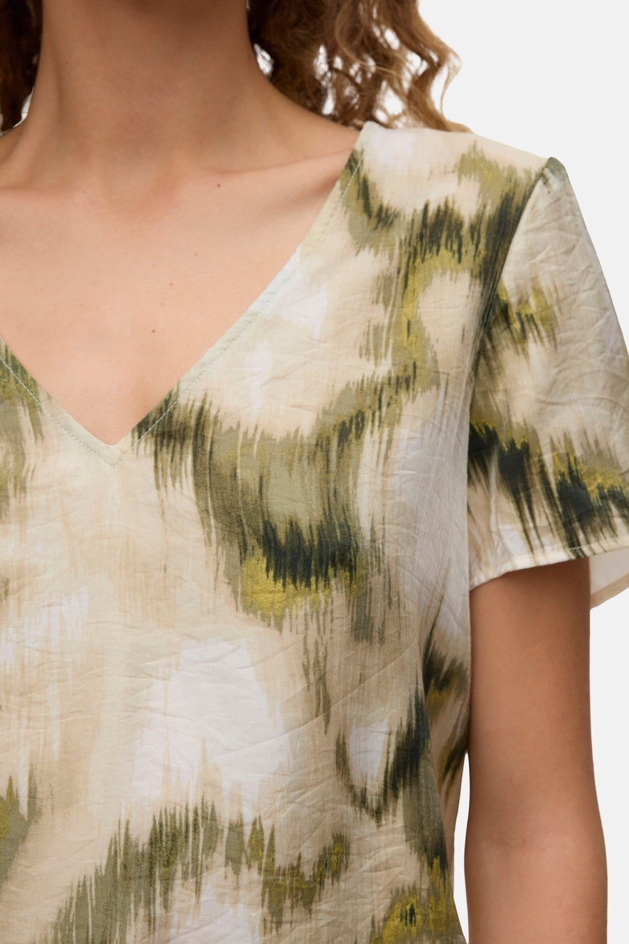 Chemisier multicolore à manches courtes de VERO MODA® avec motif à rayures abstraites vertes, beiges et blanches et col en V.