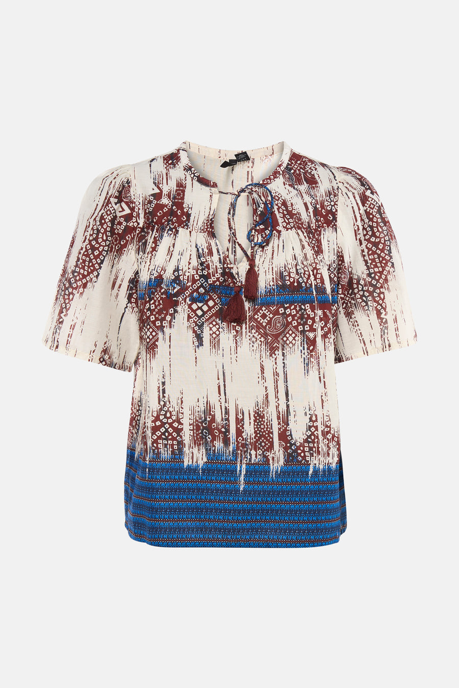 Chemisier multicolore à manches courtes de VERO MODA® avec des motifs abstraits et tribaux rouges et bleus, et des pompons au col.