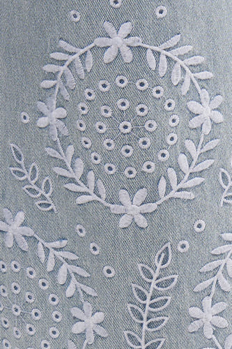 Jean large bleu clair de Vero Moda avec broderie florale et perforations décoratives.
