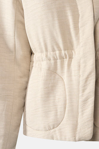 Manteau court beige de Vero Moda, avec cordon à la taille et poches arrondies.