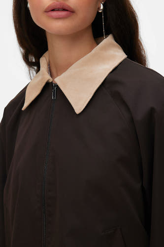 Manteau marron de VERO MODA avec col beige et boucles d'oreilles argentées.