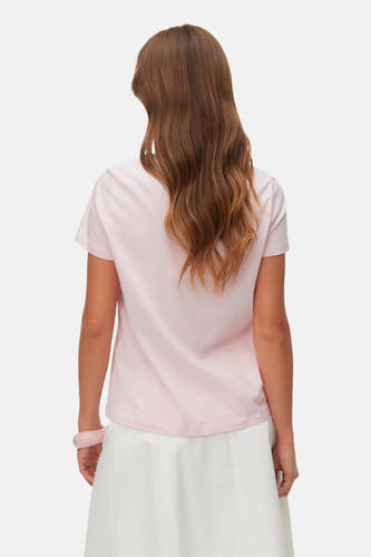 Roze T-shirt met korte mouwen van VERO MODA®, gezien van achteren, gecombineerd met een witte rok.
