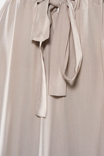 Robe beige de VERO MODA® avec une ceinture à nouer et un tissu texturé visible.