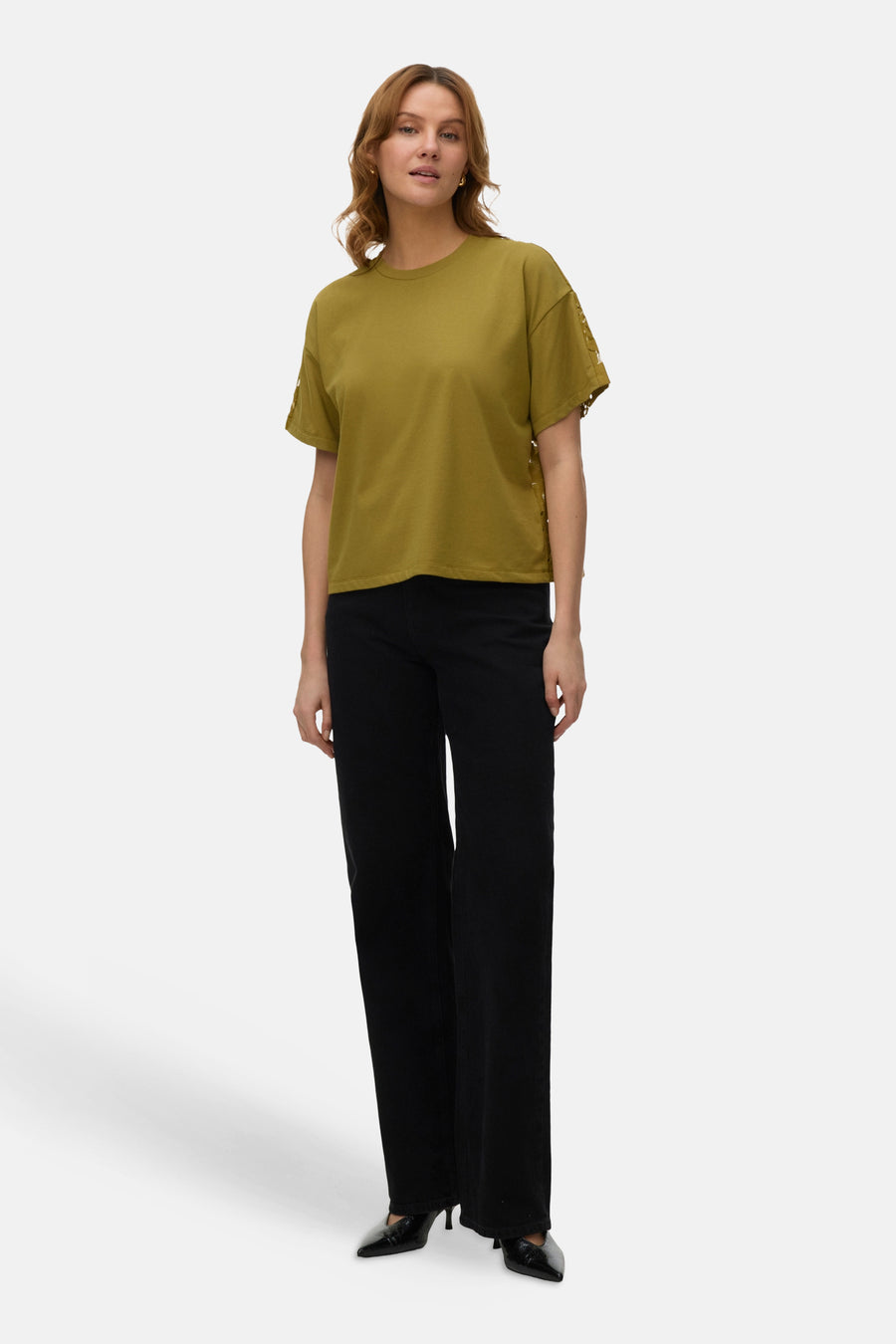 T-shirt vert à manches courtes de VERO MODA, fini avec des détails décoratifs sur les côtés, combiné avec un pantalon noir.