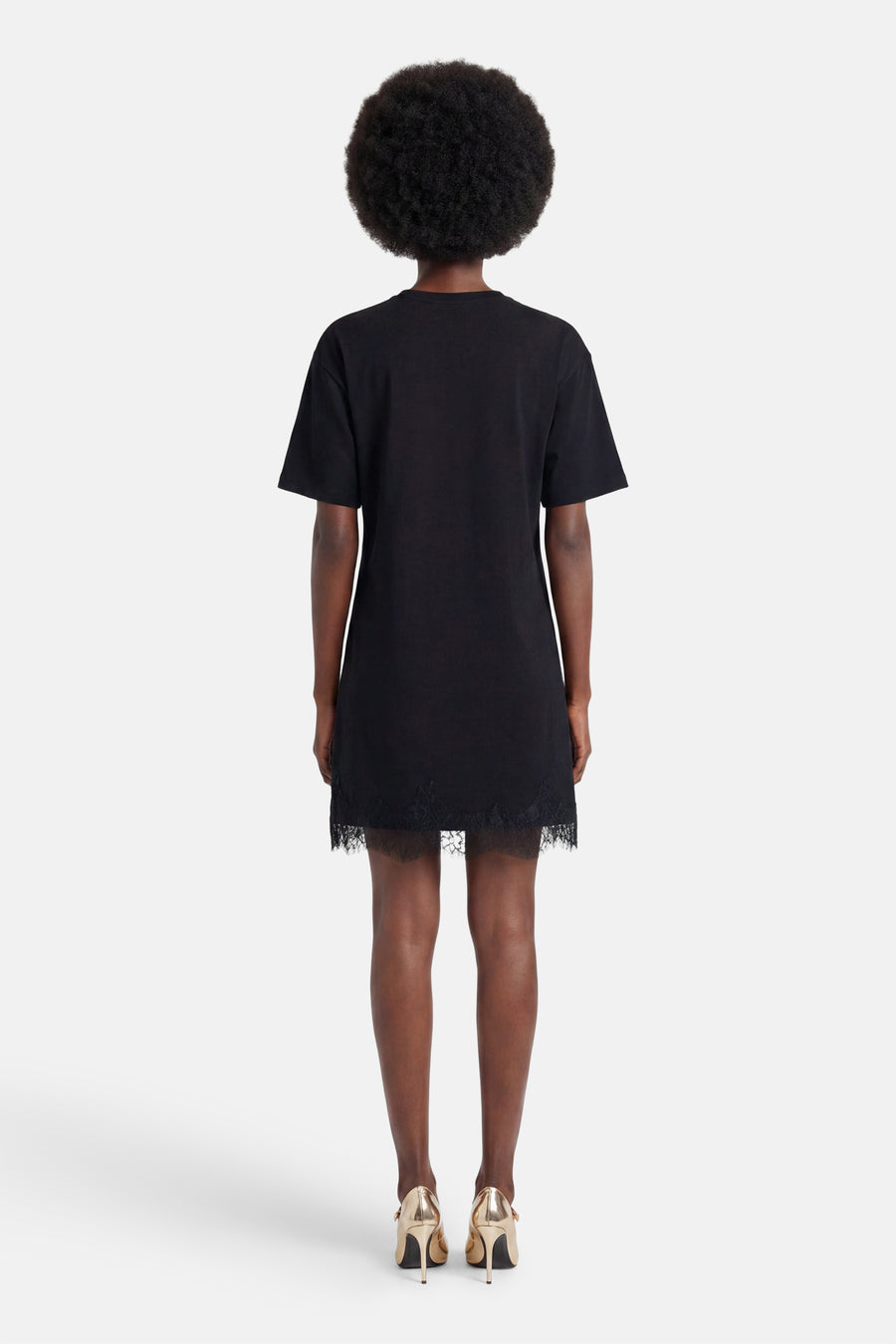 Robe noire à manches courtes de VERO MODA, avec ourlet décoratif en dentelle, photographiée de dos.