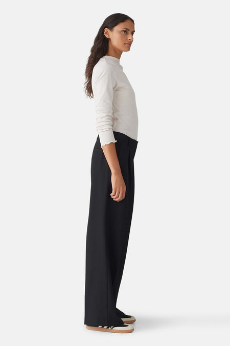 Pantalon noir ample OPUS avec plis, porté par un mannequin de profil.