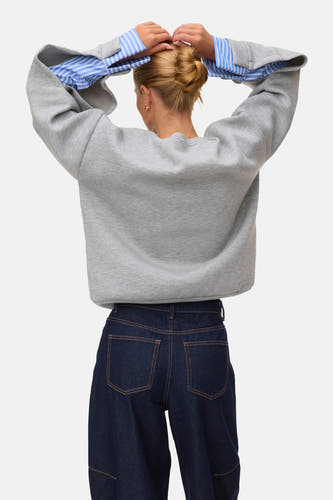 Grijze ronde hals sweater van VERO MODA®, achterzijde met blauw-wit gestreepte mouwen en donkerblauwe jeans, casual look