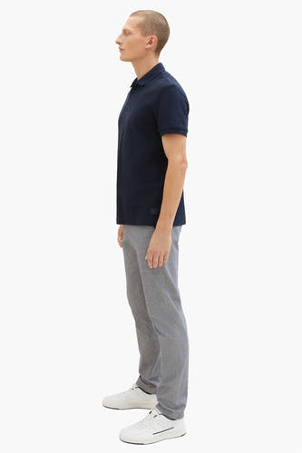 Chino gris de TOM TAILOR, vu de côté, associé à un polos bleu marine et des baskets blanches.