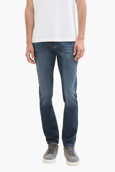 Jean slim bleu marine de TOM TAILOR, en denim délavé avec une texture usée subtile, vue de face sur un mannequin portant un t-shirt blanc et des baskets grises