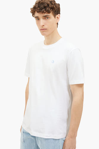 T-shirt blanc de TOM TAILOR, avec des manches courtes et un petit logo sur la poitrine, associé à un jean bleu clair.