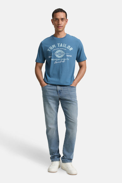 T-shirt bleu à manches courtes de TOM TAILOR, avec impression, associé à des jeans et des chaussures blanches.