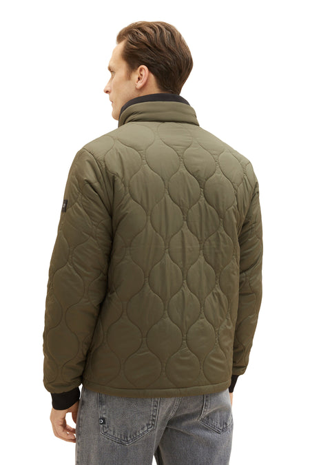 Veste verte de TOM TAILOR, avec un motif de visière effiloché, vue depuis l'arrière, avec un homme en jeans.