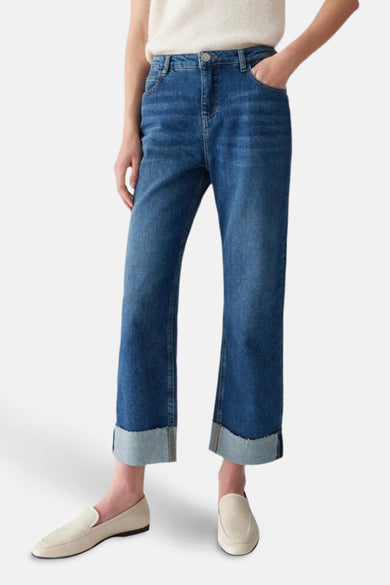 Jean droit en denim bleu marine d'OPUS, avec des poches surmontées et des loafers légers de couleur crème.