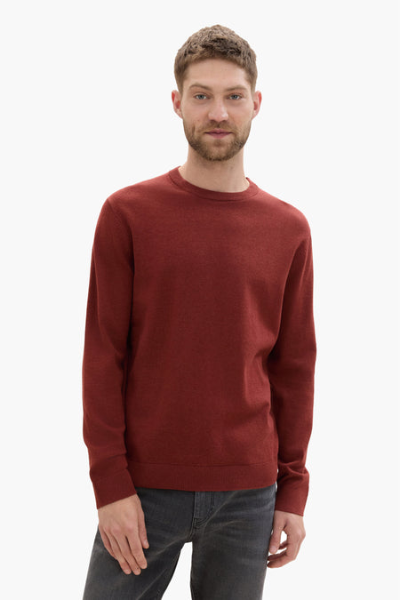 Pull rouge à col rond de Tom Tailor, porté avec un jean gris.