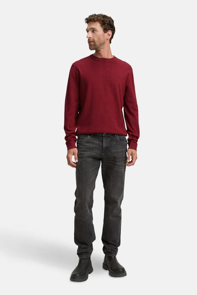 Pull rouge à col rond de TOM TAILOR, associé à des jeans gris foncé et des bottes noires.