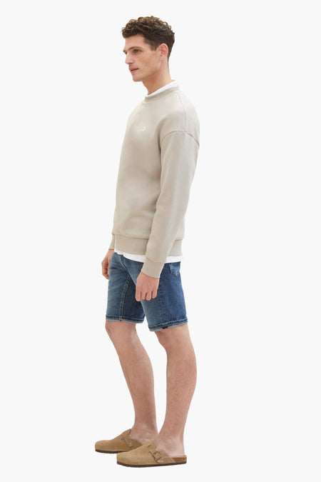 Jean court bleu marine de TOM TAILOR, associé à un sweat-shirt beige et des mocassins en cuir de mouton, vue latérale.