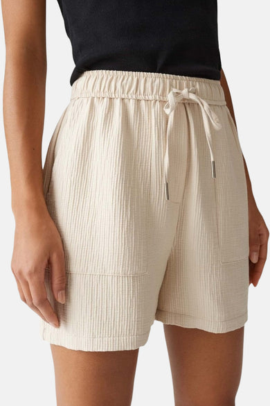 Beige court d'OPUS, vu de derrière, avec une ceinture élastique et une subtile texture.