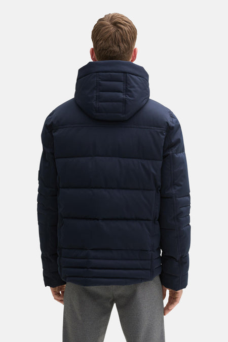 Manteau court bleu de TOM TAILOR, vu de l'arrière avec un capuchon et un pantalon gris.