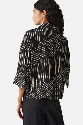 Chemise noire à longues manches d'OPUS, avec un motif blanc abstrait sur le dos.