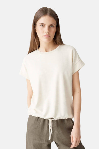 T-shirt écru à manches courtes d'OPUS, avec une subtile texture et porté avec un pantalon vert olive à cordon.