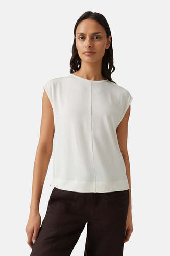 Witte mouwloze T-shirt van OPUS, minimalistisch ontwerp met centrale naden, gedragen door model in lifestyle pose