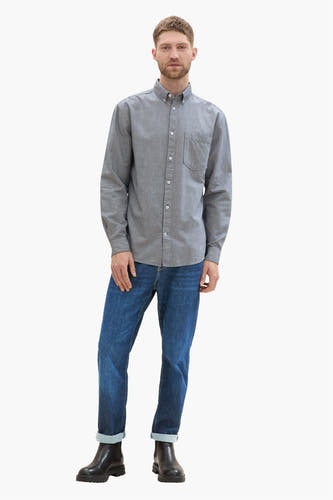 Chemise bleue à manches longues de TOM TAILOR, avec col boutonné, portée avec des jeans et des bottes noires.