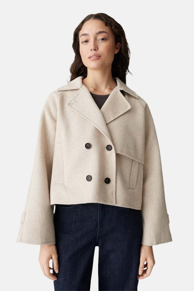 Mauve manteau court d'OPUS, avec une fermeture à double boutonnage et des manches larges, porté avec un pantalon foncé.