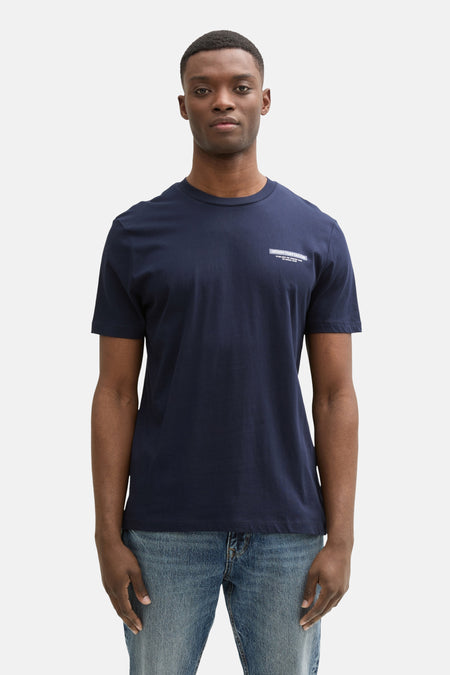 T-shirt bleu à manches courtes de TOM TAILOR, avec une impression sur la poitrine, porté avec des jeans bleus.
