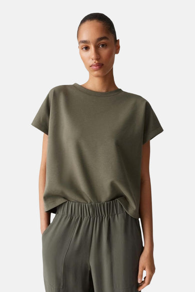 Pull-over vert de OPUS, combiné avec un pantalon de la même couleur.