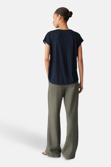 Zwarte blouse met korte mouwen van OPUS, achterkant, gecombineerd met een groene broek.
