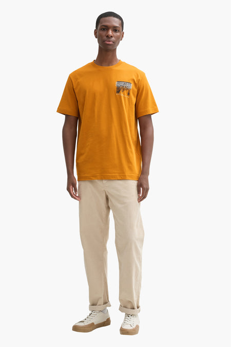 T-shirt jaune à manches courtes de TOM TAILOR, avec une petite impression sur la poitrine, associé à des pantalons beige et des baskets.
