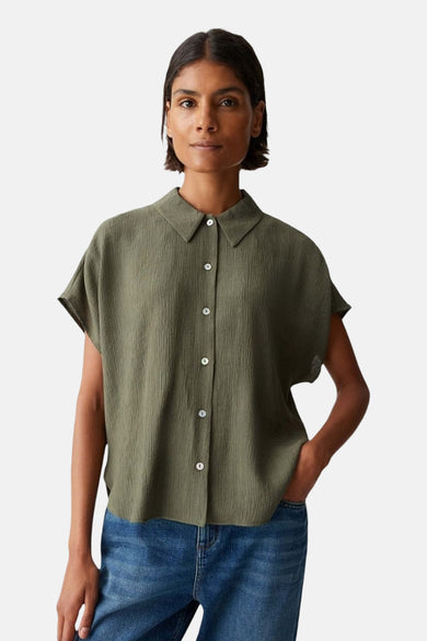 Chemise verte à manches courtes d'OPUS, avec une subtile texture et portée avec un jean bleu.