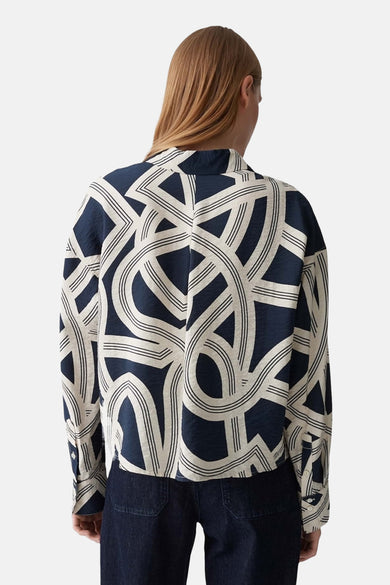 Chemise bleue à longues manches d'OPUS, avec un motif géométrique abstrait sur le dos.