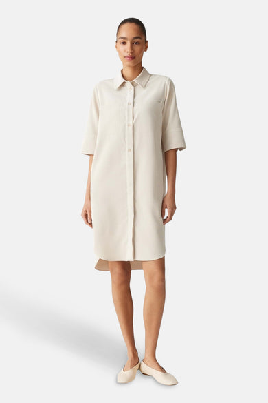 Manteau beige d'OPUS, avec des manches courtes et une fermeture à boutons.
