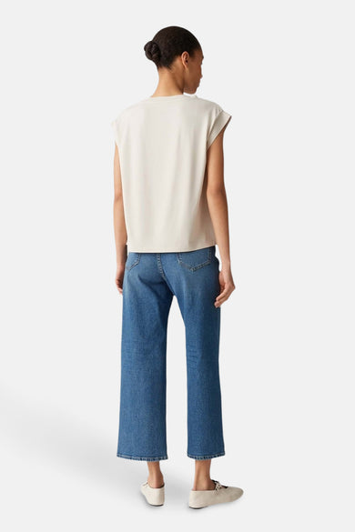 Ecru blouse zonder mouwen van OPUS, met een rechte pasvorm, gedragen met blauwe jeans.
