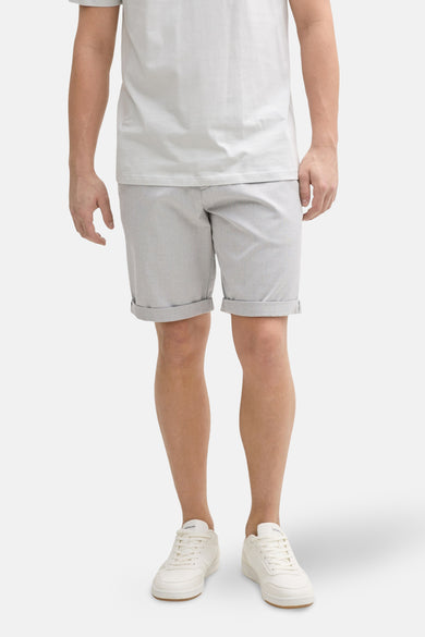 Veste grise TOM TAILOR avec col rabattu, associée à un t-shirt blanc et des baskets blanches.