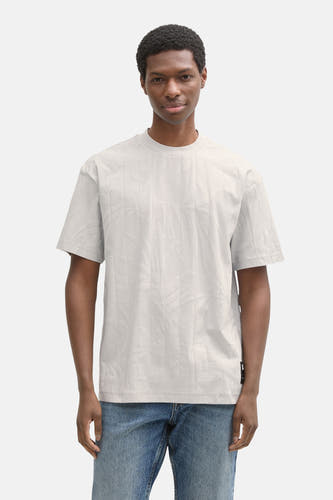 T-shirt gris à manches courtes de TOM TAILOR, avec une impression relief de feuilles, porté avec des jeans.