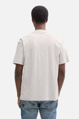Grijs T-shirt met korte mouwen van TOM TAILOR, met een reliëfprint van bladeren, gedragen met jeans.
