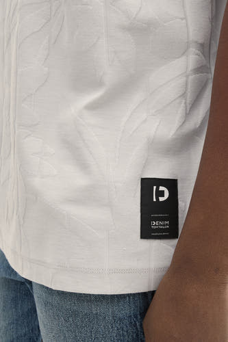 T-shirt gris à manches courtes de TOM TAILOR, avec un motif de feuille subtil et une étiquette de marque noire sur l'ourlet, porté avec un jean.