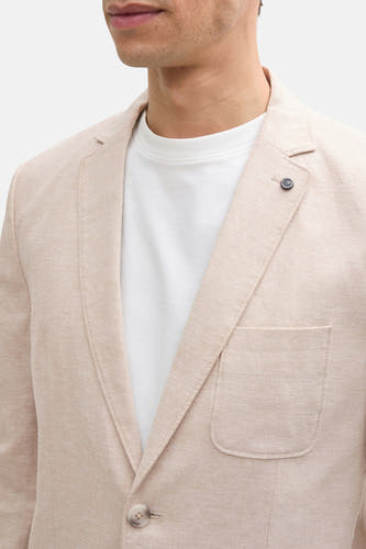 Blazer beige de TOM TAILOR, avec un t-shirt blanc en dessous et une patte de boutonnage.