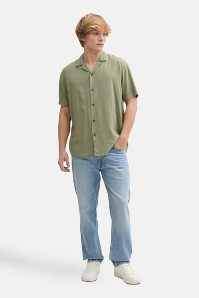 Kaki hemd met korte mouwen van TOM TAILOR, met knoopsluiting en gedragen met een blauwe jeans.