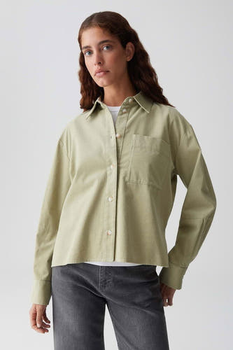Blouse verte avec manches longues d'OPUS, vue de dos avec un col net et une coupe droite, associée à un jean gris.