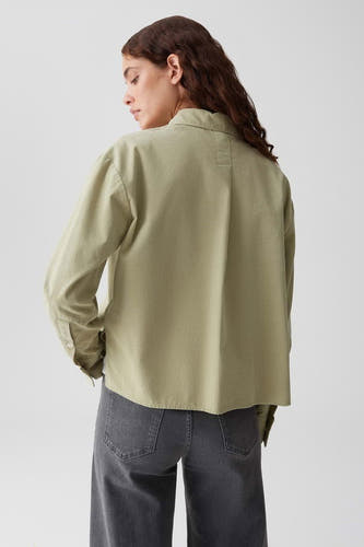 Groene blouse met lange mouwen van OPUS, gezien van achteren met een nette kraag en rechte pasvorm, gecombineerd met een grijze jeans.
