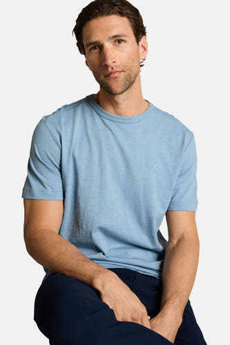 T-shirt bleu à manches courtes de TOM TAILOR, porté par un homme assis avec un pantalon foncé.