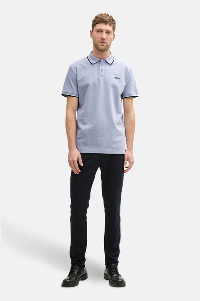 Polo bleu à manches courtes de TOM TAILOR, avec une patte blanche sur le col et les manches.