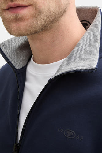 Gilet bleu de TOM TAILOR, avec un col gris et un t-shirt blanc en dessous.