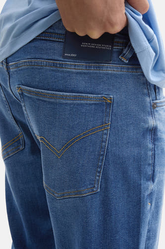 Jean slim en denim bleu moyen de Tom Tailor, avec des boutons décoratifs sur les poches arrière, gros plan.