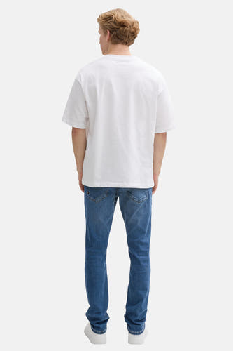 Blauwe rechte jeans de TOM TAILOR, gezien van achteren, met witte schoenen en een wit T-shirt.

